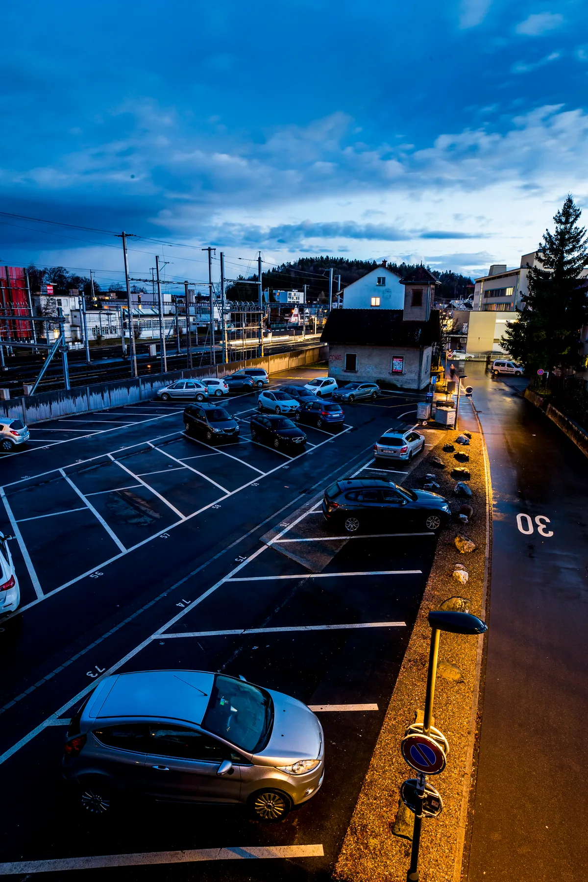 Parkplatz und Strasse mit Beleuchtung. 